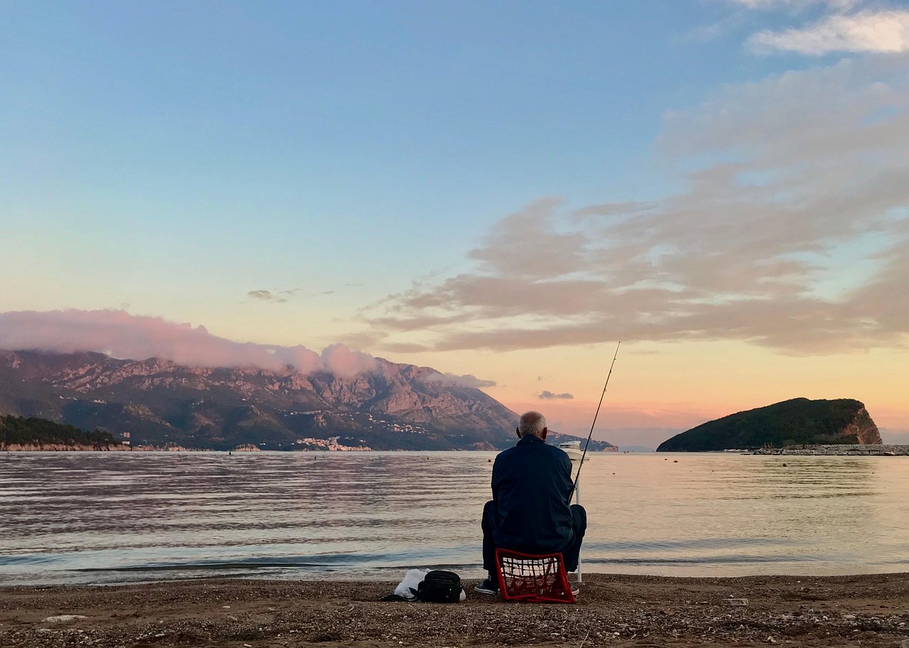Angler fishing at a calm Australian coastline at sunset